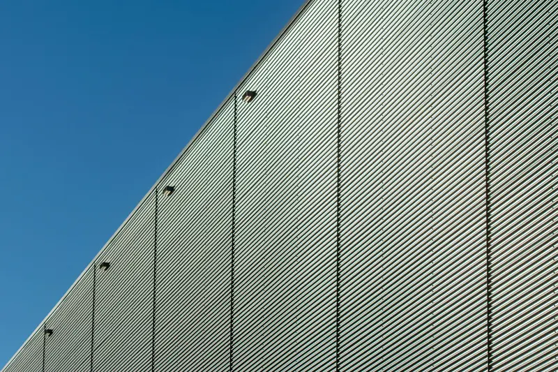 Corrugated metal wall of a building against a blue sky