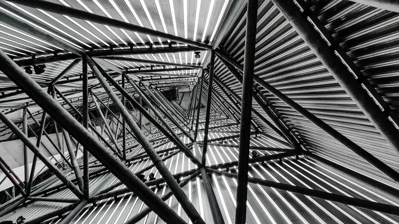 Black-and-white view up into a steel frame structure